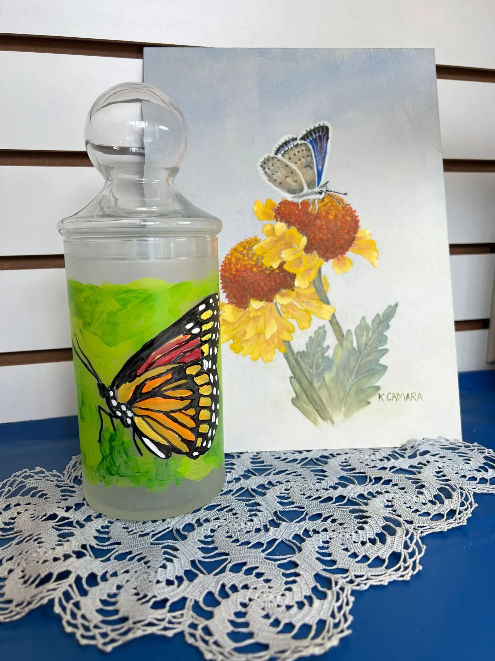 Butterfly-themed artwork display with lace cloth