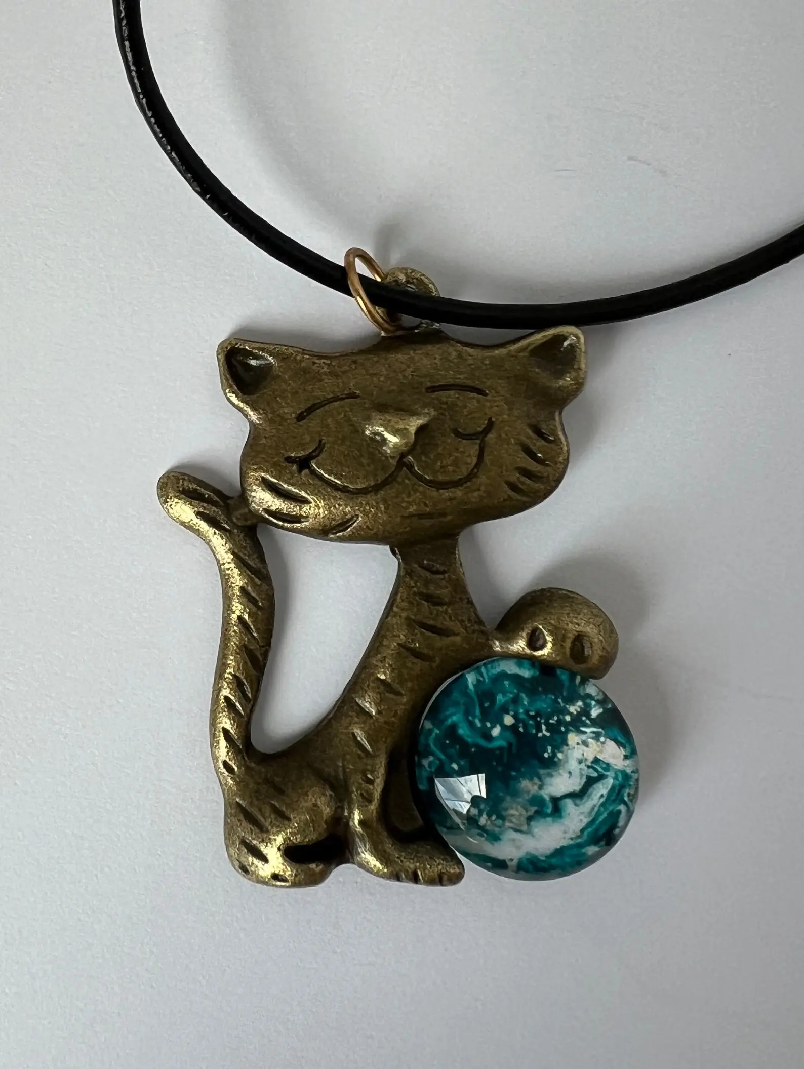 Whimsical cat charm on black cord