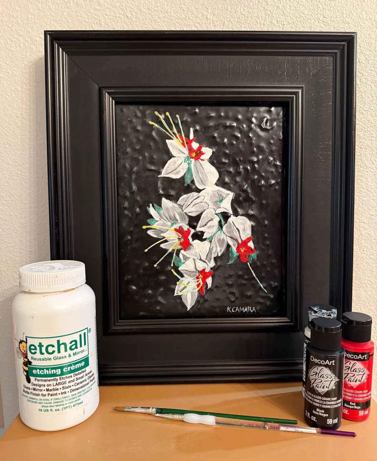 Etching cream and paints beside floral art