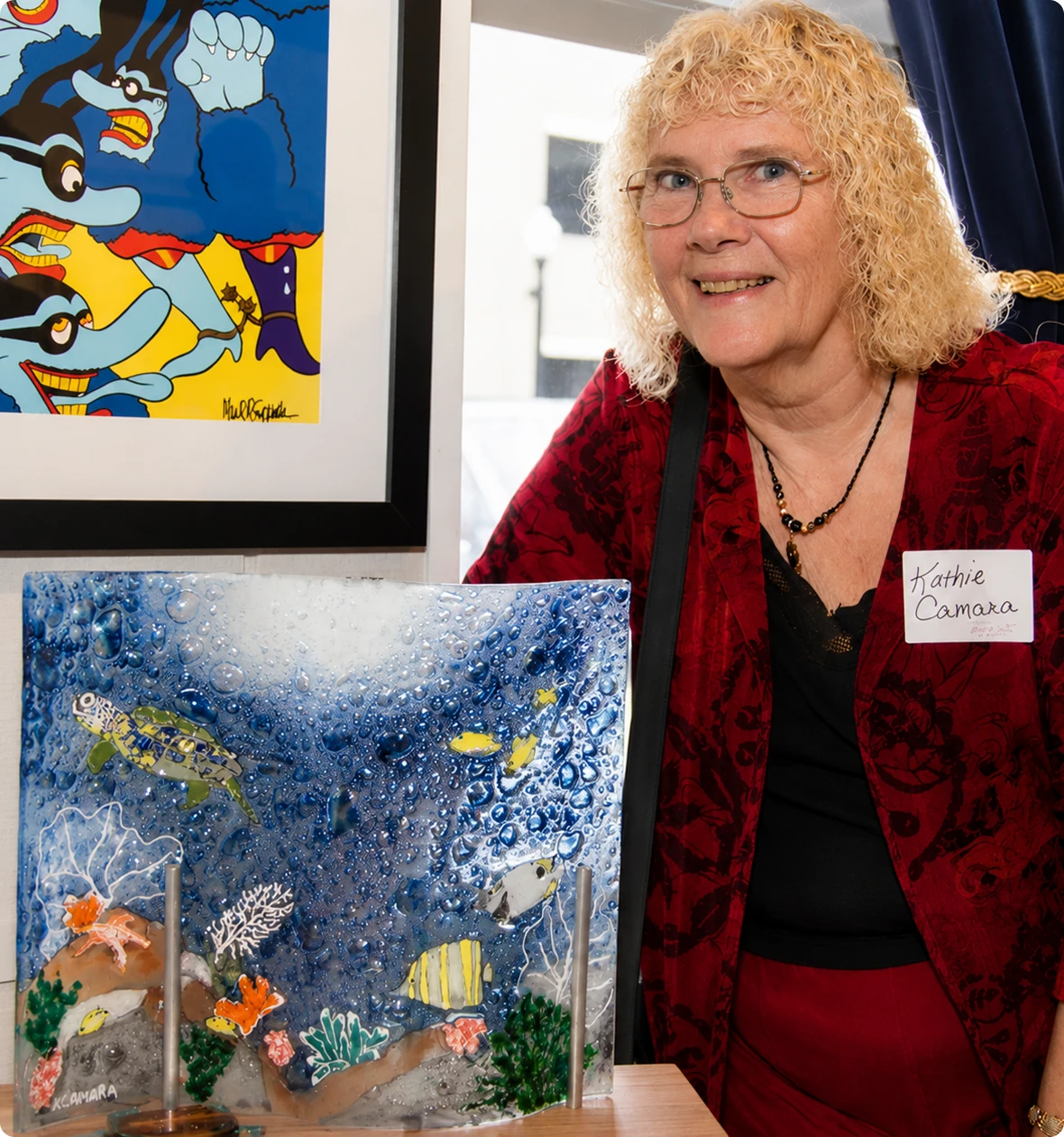 Smiling artist beside her creative piece