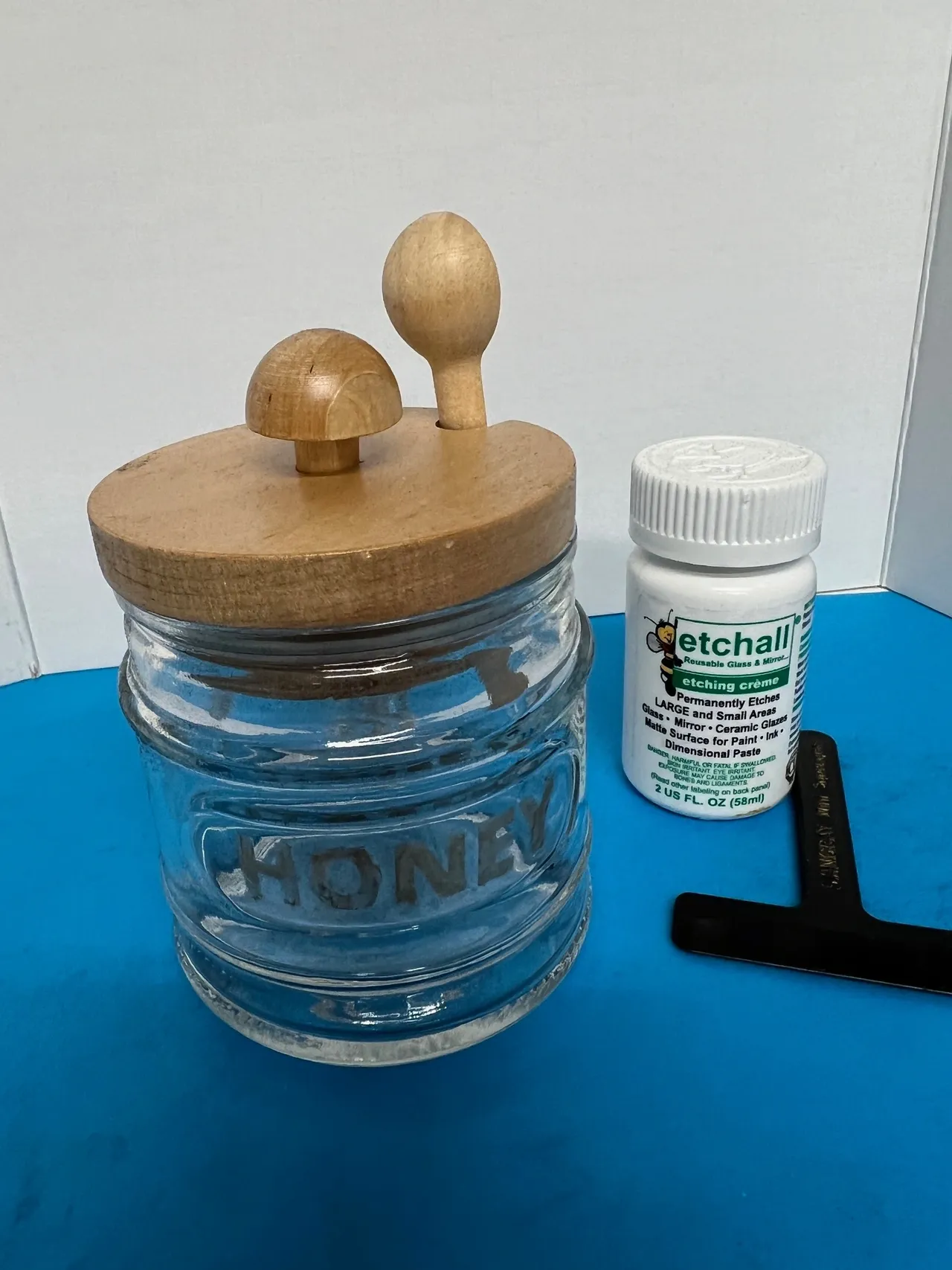 Honey jar and etching cream on table.