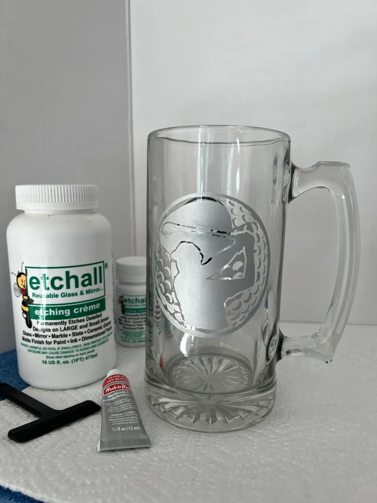 Etching supplies and etched glass mug displayed.