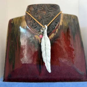 White leaf pendant necklace on display bust